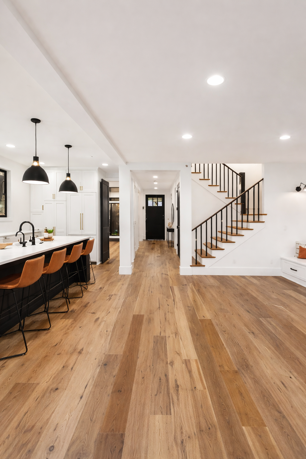 Modern kitchen and staircase with wide-plank hardwood floors