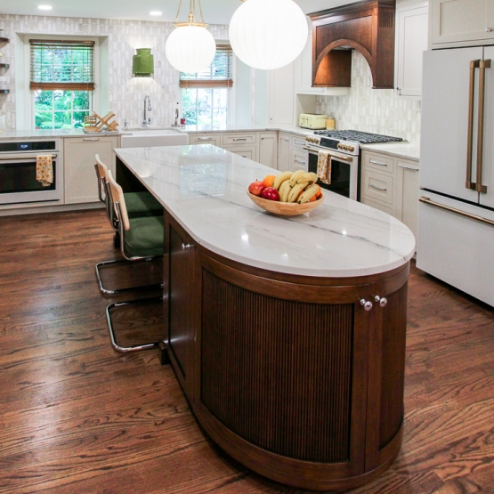 Kitchen with rich hardwood flooring and custom curved island