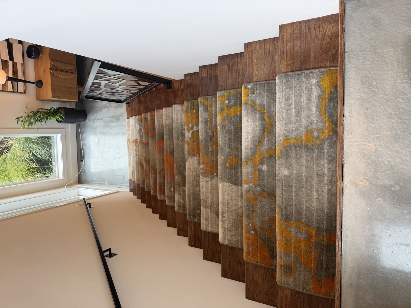 Custom carpet stair runners with abstract gray and orange pattern viewed from top of staircase