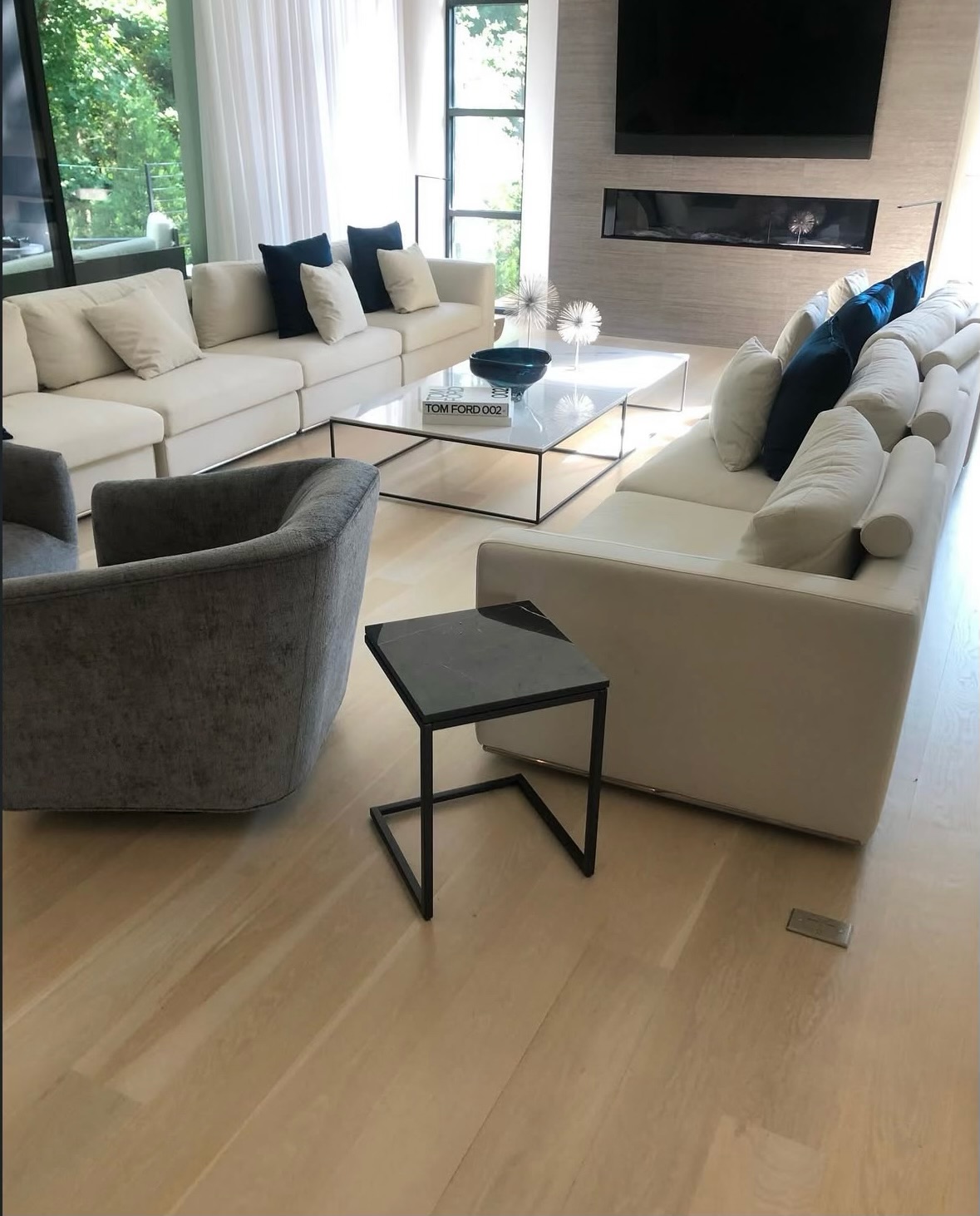 Luxury living room with light wide-plank hardwood floors and fireplace